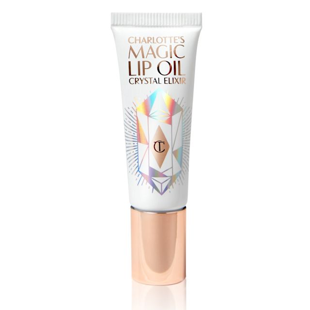 A lip oil in a white coloured tube with reflective geometric patterns on it in silver colour and a rose-gold-coloured lid. 