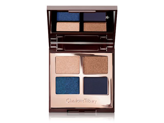 An open, mirrored-lid quad eyeshadow palette with shimmery and matte eyeshadows in shades of blue and gold. 