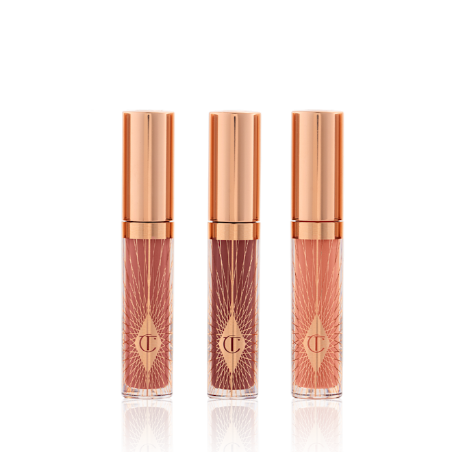 Mini Collagen Lip Bath Trio closed Three, travel-size lip glosses in shades of light pink, coral-peach, and brown-pink in glass tubes with gold-coloured lids.