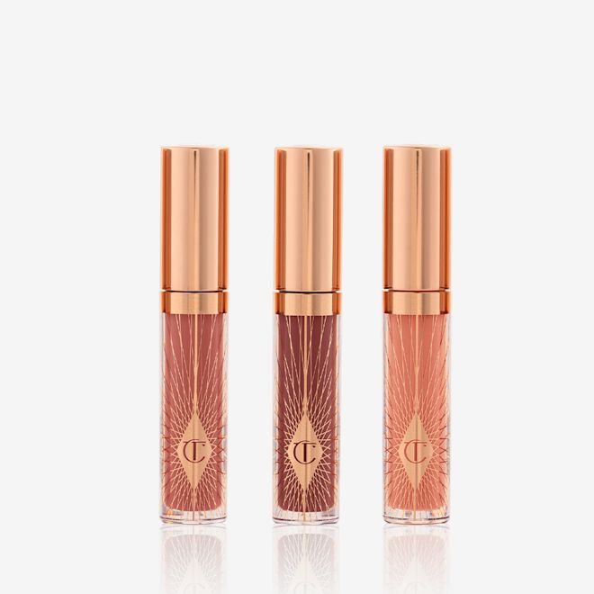 Mini Collagen Lip Bath Trio closed Three, travel-size lip glosses in shades of light pink, coral-peach, and brown-pink in glass tubes with gold-coloured lids.