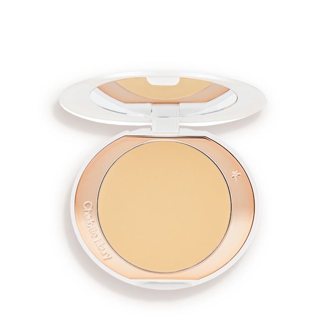 Airbrush Brightening Flawless Finish compact open An open, setting powder compact with a mirrored-lid and white and gold-coloured packaging.