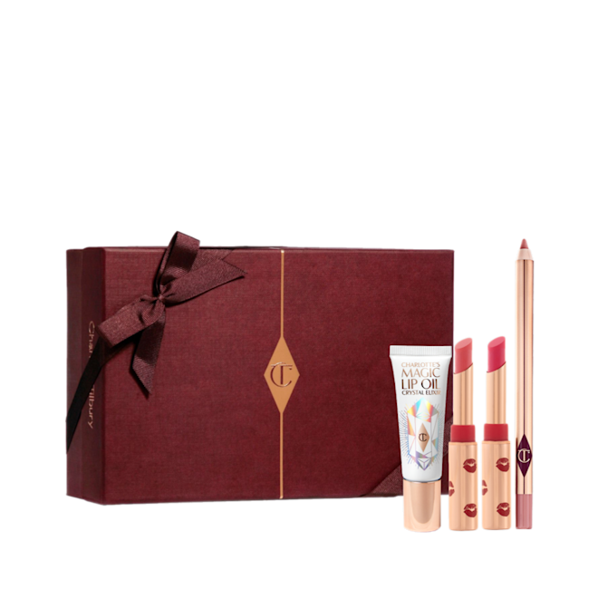 Lucky Lip Secrets Box-Gift-Box Two open lipsticks in burnt orange and bright pink colours with gold-coloured tubes with red-coloured kiss pattern all over, an open lip liner pencil in nude pink, and lip oil in a white-coloured tube with gold-coloured lids, along with a light pink-coloured makeup sleeve with text in rose gold on it that reads, 'you are my star. I love you'