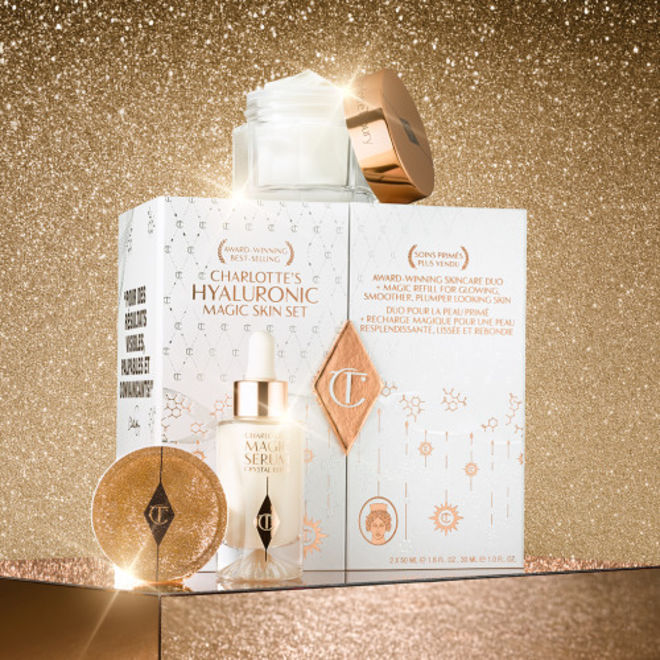 Imagen de Hyaluronic Magic Skin Set Estuche para el cuidado de la piel de color blanco y dorado que incluye un sérum facial luminoso en un frasco de cristal y una crema facial de color blanco nacarado en un tarro de cristal con tapa dorada con una muestra.