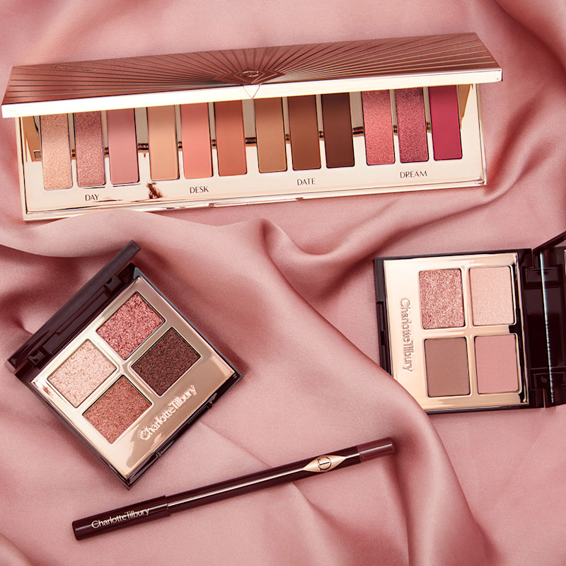 Banner with a 12-pan eyeshadow palette and two quad eyeshadow palettes with eyeshadows in shades of pink, gold, peach, and brown along an eyeliner pen in a berry-brown colour.