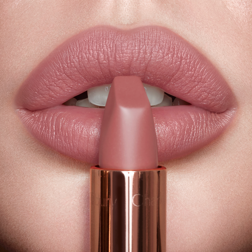 Model wearing Pillow Talk Original Matte Revolution nude-pink lipstick