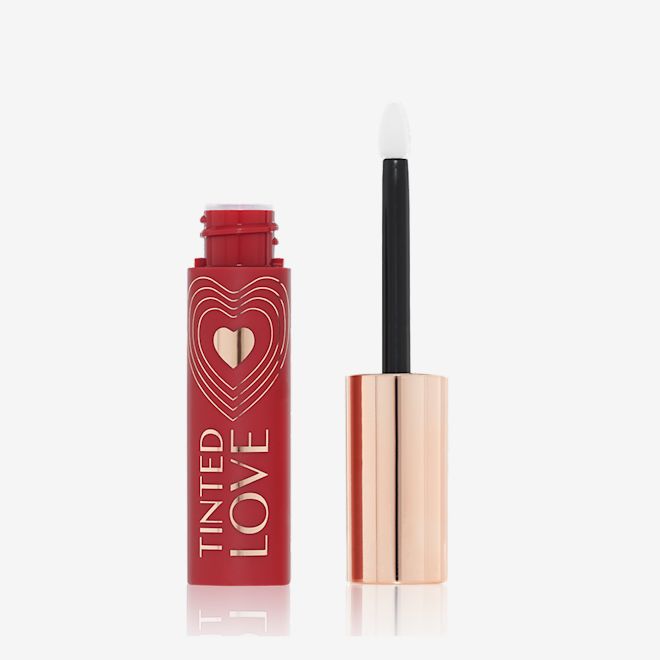 Tinted Love in Love Chain open An open lip and cheek tint with a gold-coloured lid in a vibrant-red-coloured tube.