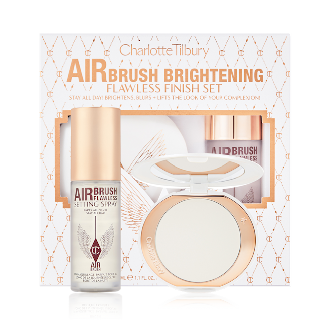 Airbrush Brightening Flawless Complexion Perfecting Set with box displayed Setting spray in a clear bottle with a gold-coloured lid with a brightening setting powder compact in gold-packaging with a mirrored-lid along with a white and pink-coloured packaging box.