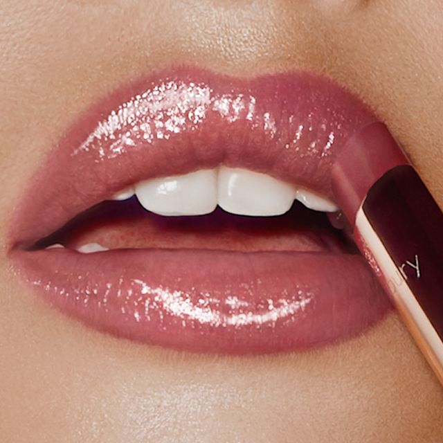 Model wearing Pillow Talk Superstar Lips nude-pink glossy lipstick