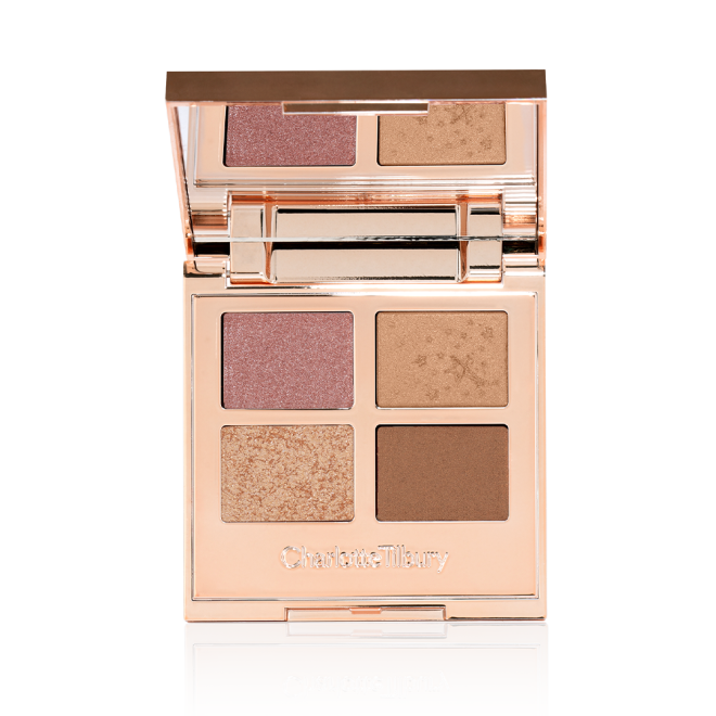 An open, mirrored-lid quad eyeshadow palette with soft earthy-tones in shades of pink, brown, and gold.