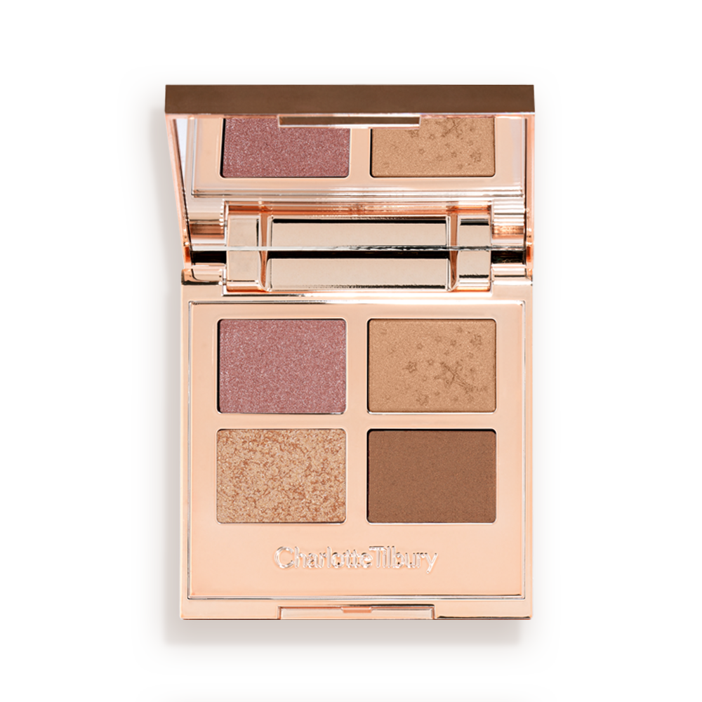 An open, mirrored-lid quad eyeshadow palette with soft earthy-tones in shades of pink, brown, and gold.
