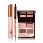 Mascara in a nude pink tube with a gold-coloured lid, an open, double-sided eyeliner pen in black and soft champagne-beige, and an open, mirrored-lid quad eyeshadow palette with matte and shimmery shades in gold and brown.