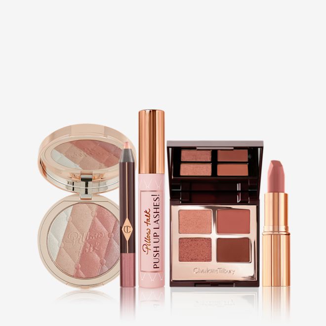 Pillow Talk Party Look Kit open An open, pressed powder highlighter compact in various shades of pink and gold for cool-tone complexions, eyeshadow stick in nude pink, black mascara, quad eyeshadow palette in shades of brown, and a nude pink matte lipstick.