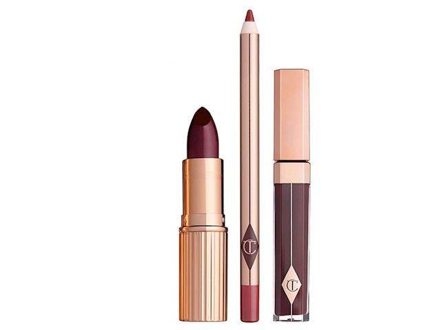 An open, vampy-red lipstick with a satin-finish, lip liner pencil in a statement red shade, and a dark crimson lip gloss. 