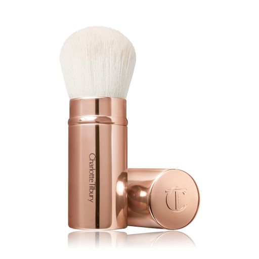 A face blending brush with white bristles in rose gold packaging.