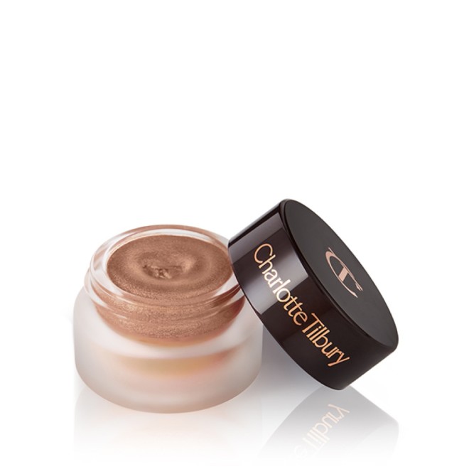 An open pot of shimmering nude cream eyeshadow with a black-coloured lid with the CT logo on it.