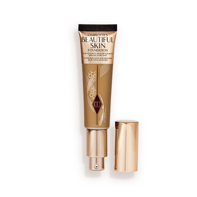 Beautiful Skin Foundation in Shade 11W open An open foundation wand in gold packaging with a pump dispenser and a dark-sandy-brown-coloured body to show the shade of the foundation inside.
