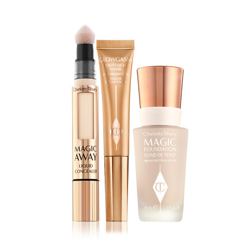 Concealer in sleek, gold-coloured tube with a soft, sponge applicator end, highlighter wand in a honey-gold-coloured tube, and foundation in a frosted glass bottle with a gold-coloured lid.