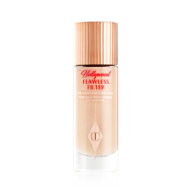 A closed, luminous primer in a light cool-toned-beige shade in a glass bottle with a gold-coloured lid.