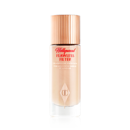 A closed, luminous primer in a light cool-toned-beige shade in a glass bottle with a gold-coloured lid.