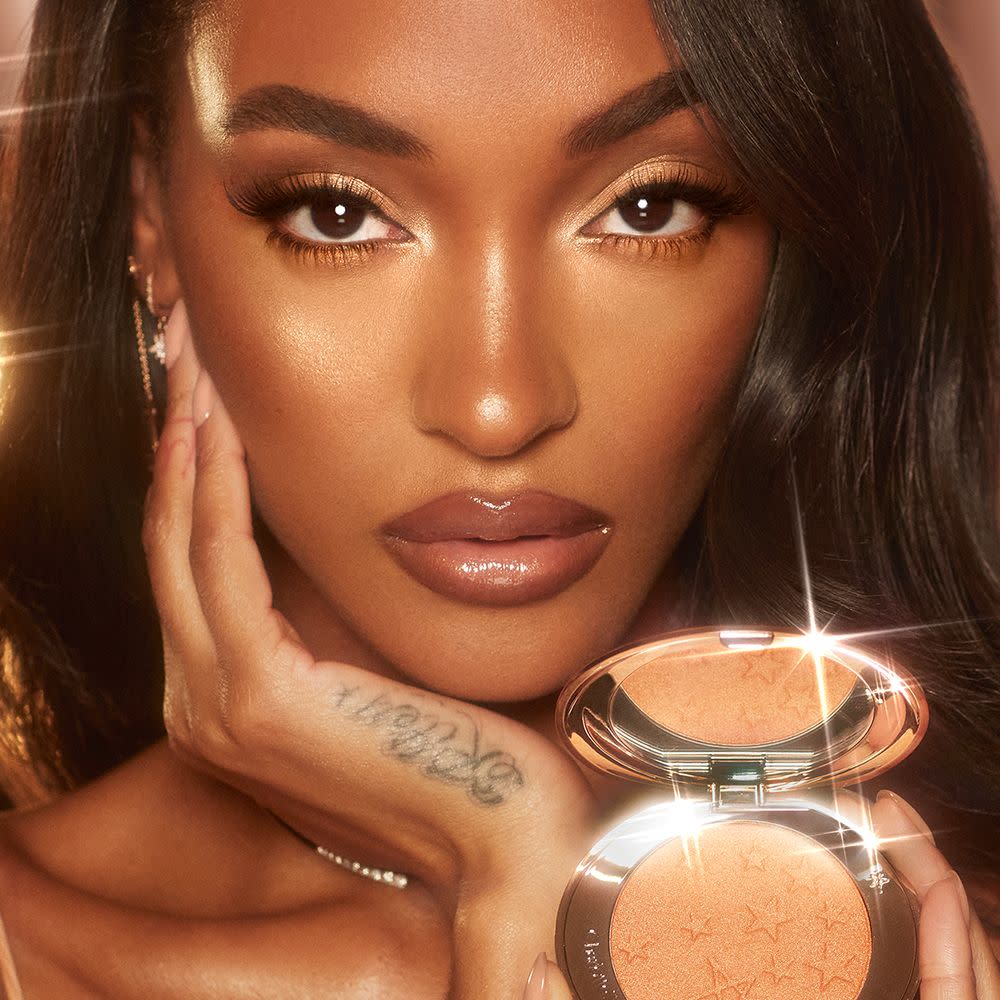 Jourdan Dunn holding Charlotte's Hollywood Glow Glide Face Architect Highlighter