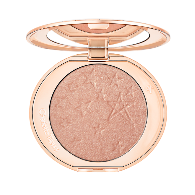 An open highlighter powder compact with a mirrored lid, in a shimmery rose gold shade. 