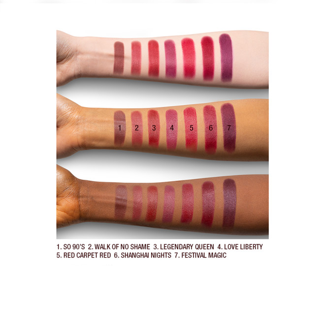 Fair, tan, and deep-tone arms with seven matte lipsticks in shades of magenta, fuchsia, ruby red, pink-red, brown-red, orange-red, and purple-red. 