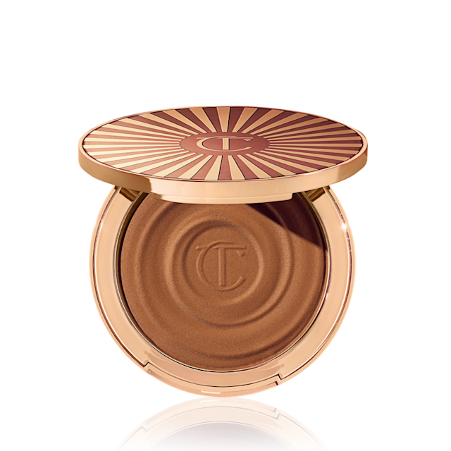 Poudrier de bronzer crème ouvert, de couleur marron moyen, dans un emballage doré.