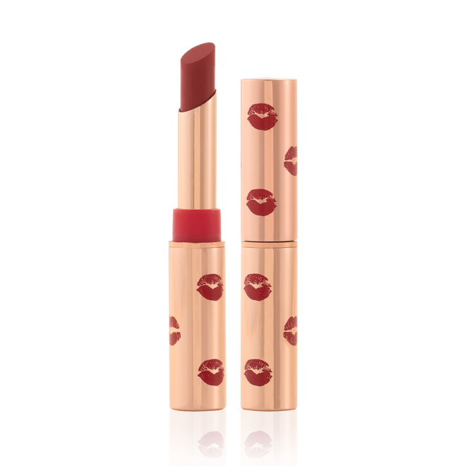 Two matte lipsticks, with and without lids, in gold-coloured tubes with kiss prints all over in rosewood red colour.