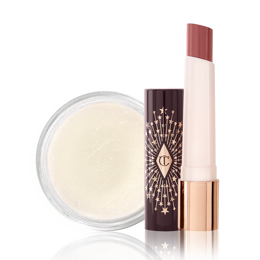 An open lipstick balm in a berry-pink shade with a white-coloured lip scrub in an open glass jar. 