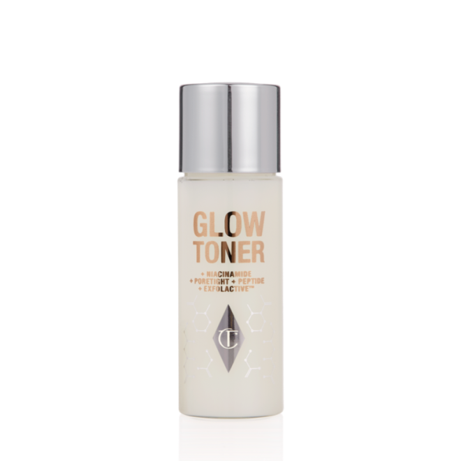 A travel-size, clear bottle filled with luminous, cream-coloured watery toner with a silver-coloured lid.