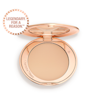 An open, pressed powder compact in a light beige shade. 