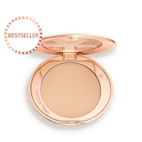 An open, pressed powder compact in a light beige shade. 