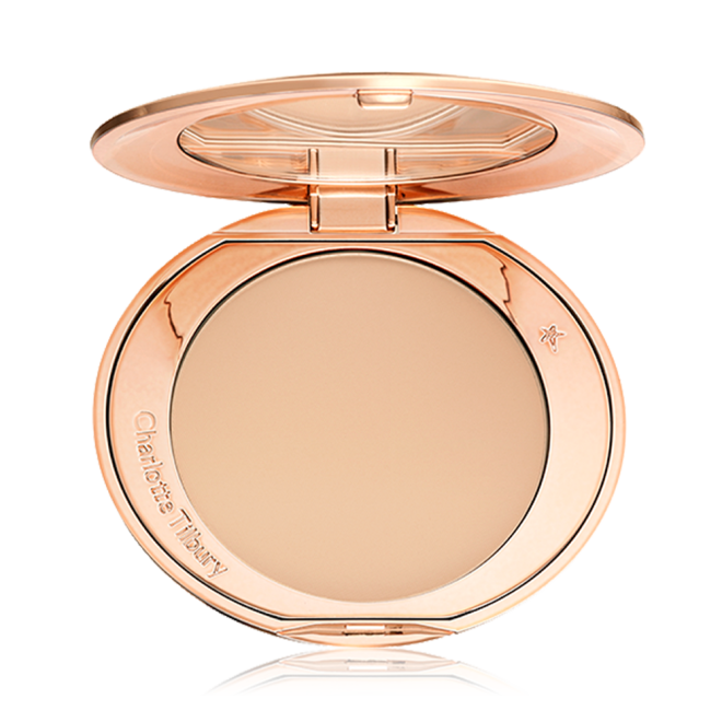 An open, pressed powder compact in a light beige shade. 