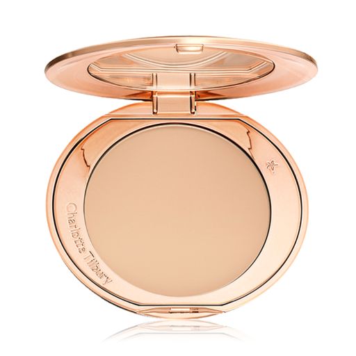 An open, pressed powder compact in a light beige shade. 