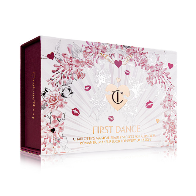 A makeup kit in a white-coloured gift box with hearts and lipstick kiss prints all over with the text, 'First kiss' written on the front. 