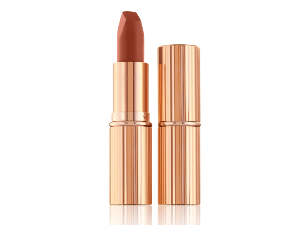 Two lipsticks, with and without lid, in a deep, sultry rose-brown nude matte shade, in sleek, gold-coloured tubes. 