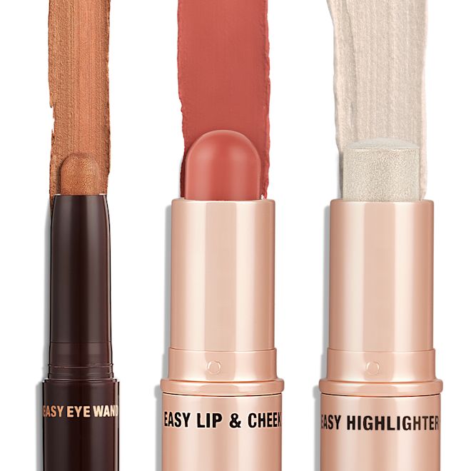 Quick & Easy Instant 5 Minute Look Golden Glow Kit products displayed An open shadow stick in a shimmery bronze shade, lip and cheek blush stick in a nude-rose shade, and highlighter stick in an opal shade.