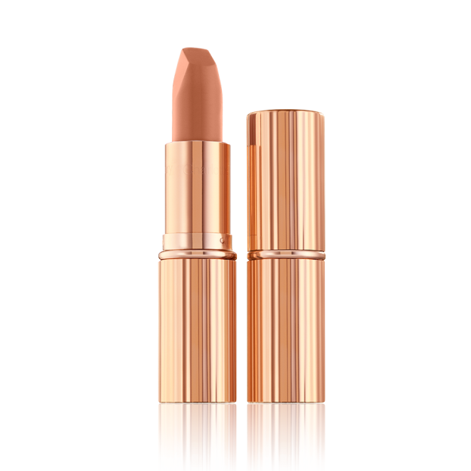 Two lipsticks, with and without lid, in a fresh, neutral nude peach matte shade, in sleek, gold-coloured tubes. 