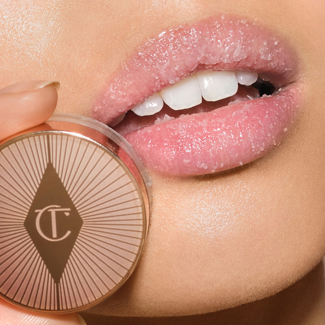 Lips close-up of a light-tone model with a thick layer of white-coloured lip scrub with sugar crystals on her lips.