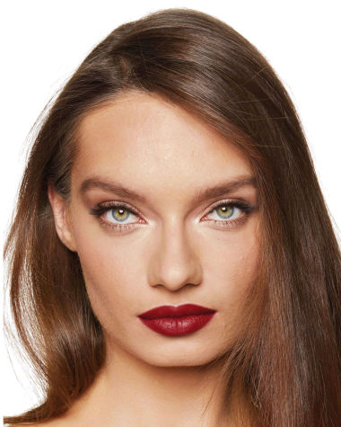 Medium-light-tone model with green eyes wearing a muted wine-red lipstick with a satin finish.