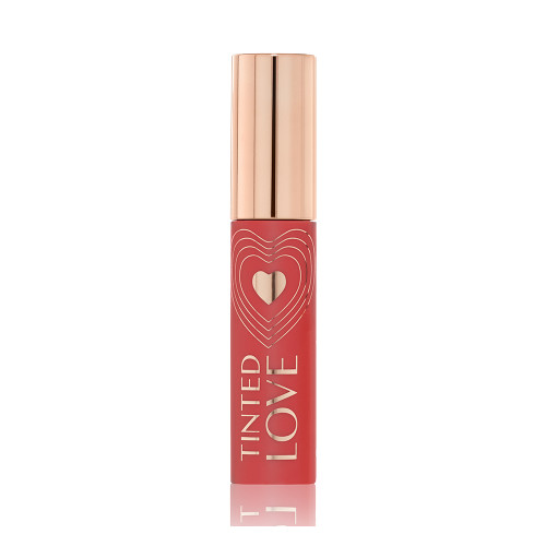 A closed lip and cheek tint with a gold-coloured lid in a warm peachy-brown-coloured tube.