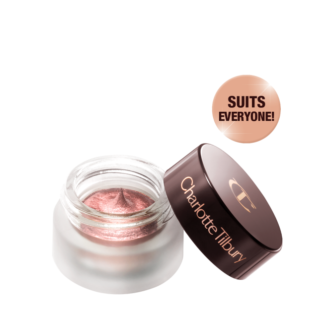 Cream eyeshadow in an open glass pot in a nude pink shade with fine shimmer, with the lid placed next to it.