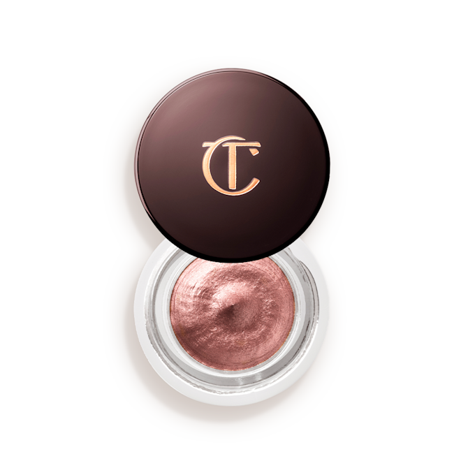 Eyes to mesmerise in Pillow Talk open Cream eyeshadow in an open glass pot in a nude pink shade with fine shimmer, with the lid placed next to it.
