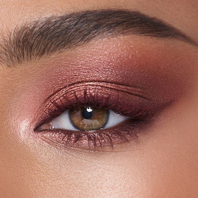 Luxury Eye Palette in Pillow Talk Dreams on hazel eye close-up Single-eye close-up of a medium-tone model with hazel eyes wearing eye makeup in shades of pearlescent rose gold, dusky rose, berry brown and rose-bud pink,