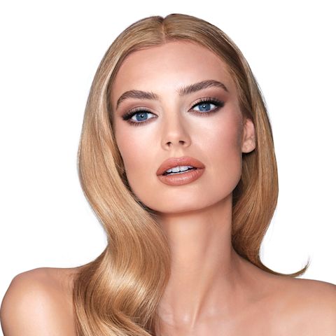 A fair-tone model with blue eyes wearing smokey brown eye makeup with muted pink blush with glossy soft-brown lips.