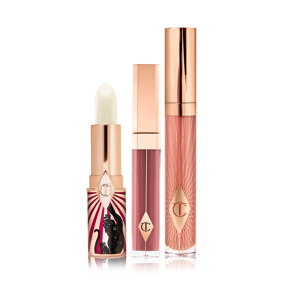 An open lip conditioner lipstick in a white colour with two lip glosses, one a sheer berry colour and the other a nude pink. 
