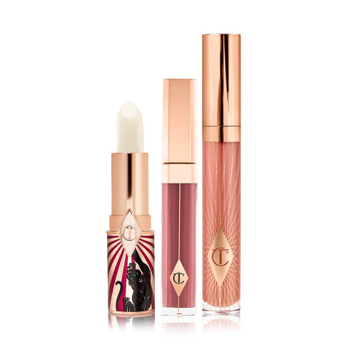 An open lip conditioner lipstick in a white colour with two lip glosses, one a sheer berry colour and the other a nude pink. 