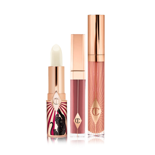 An open lip conditioner lipstick in a white colour with two lip glosses, one a sheer berry colour and the other a nude pink. 