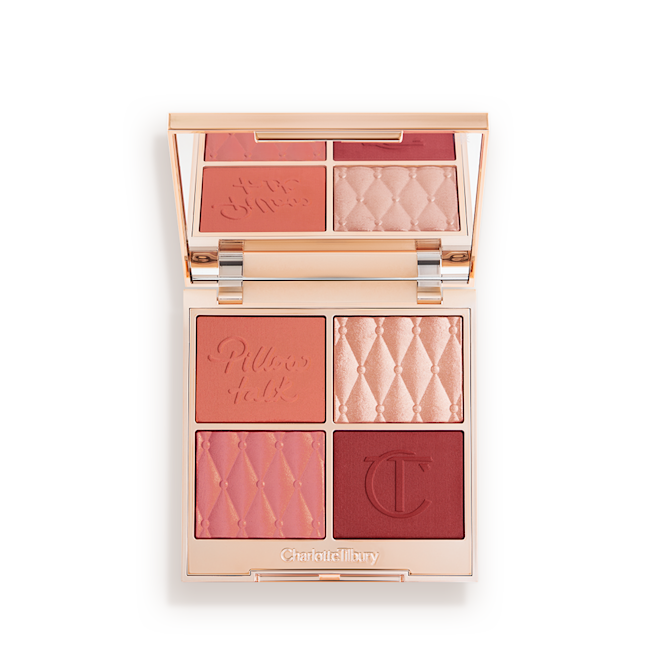 Pillow Talk Beautifying Face Palette in Medium-Deep open An open, face palette with matte and shimmery eyeshadows, blushes and highlighters in shades of pink, red. and gold with a mirrored lid.