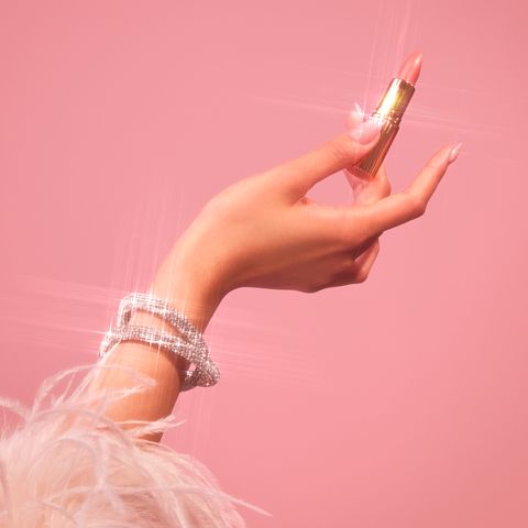 Model holding one of Charlotte's gorgeous, giftable lipsticks
